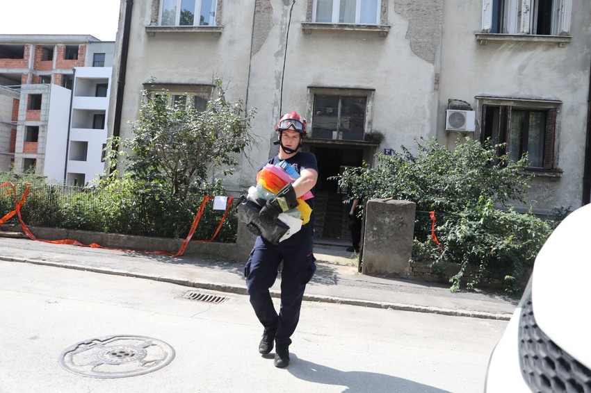 Vatrogasac pomaže u iznošenju stvari 