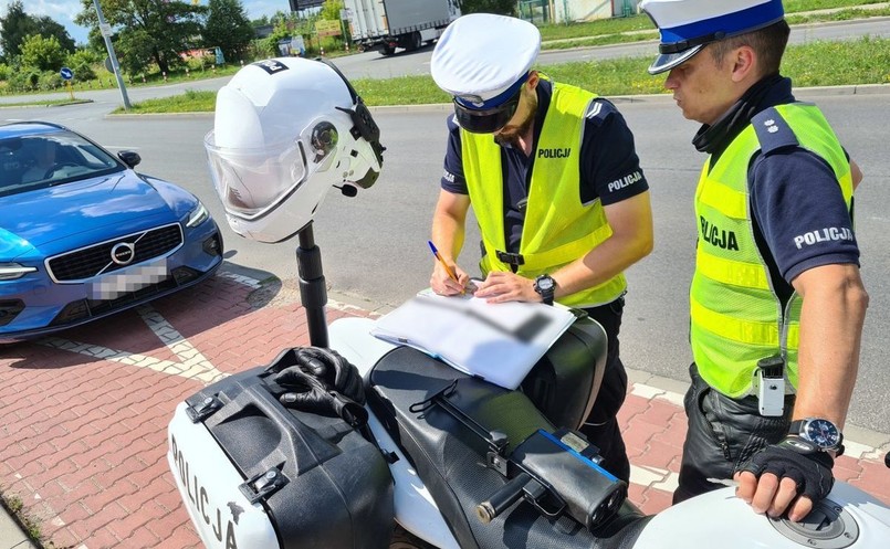 Policjant wypisuje mandat