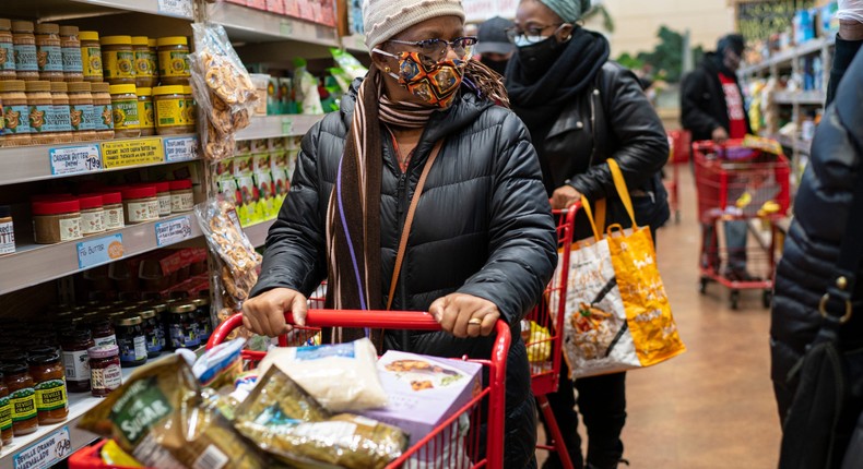 A woman wearing a mask moves her shopping cart December 3, 2020 in a Trader Joe's supermarket in New York City.
