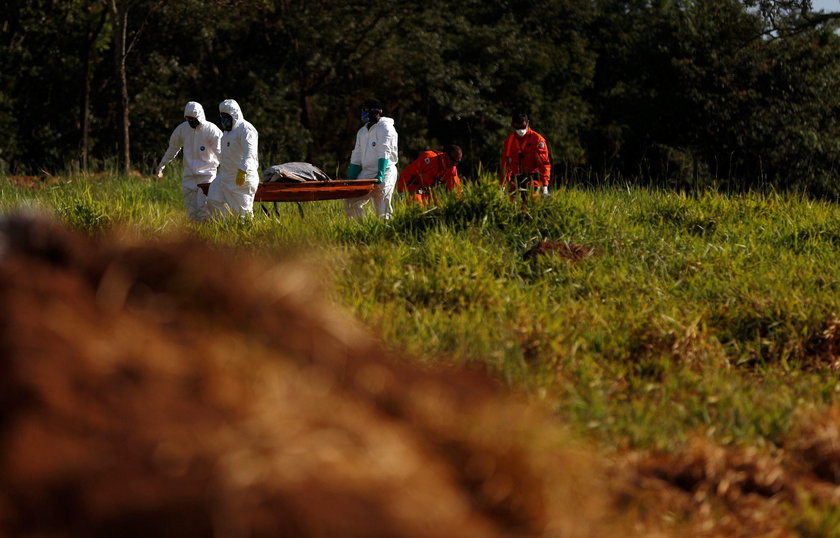 Members of a rescue team carry a body recovered after a tailings dam owned by Brazilian mining compa