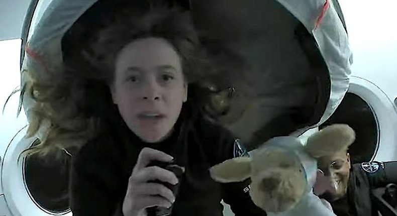 A screengrab from a live broadcast from the Crew Dragon spaceship shows Hayley Arceneaux holding up Jude the plush dog, September 17, 2021.
