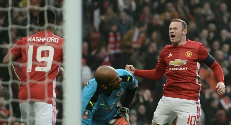 Manchester United's Wayne Rooney (R) celebrates scoring the opening goal and equalling Bobby Charlton's Manchester United all-time scoring record during the English FA Cup third round football match between Manchester United and Reading