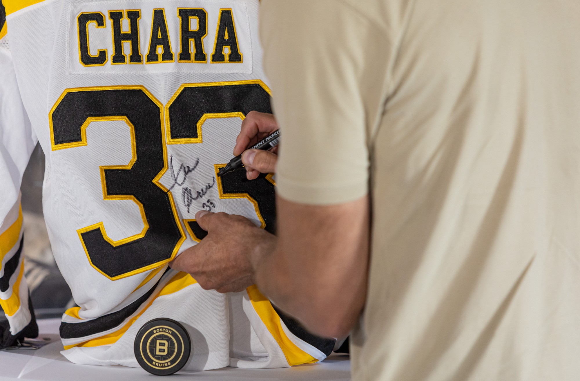 Bývalý slovenský hokejista a bývalý kapitán Bostonu Bruins Zdeno Chára podpisuje dres Bostonu Bruins.