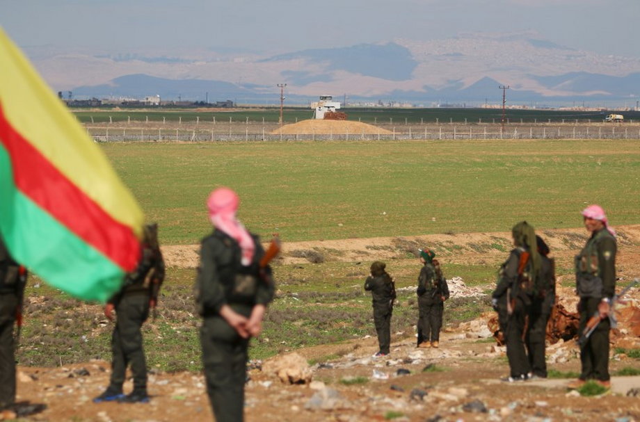 Kurdish members of the Self-Defense Forces stand near the Syrian-Turkish border in the Syrian city of al-Derbasiyah during a protest against the operations launched in Turkey by government security forces against the Kurds