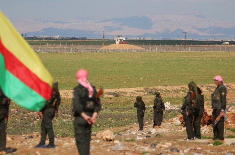 Kurdish members of the Self-Defense Forces stand near the Syrian-Turkish border in the Syrian city of al-Derbasiyah during a protest against the operations launched in Turkey by government security forces against the Kurds