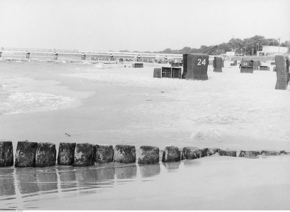 Kosze plażowe na plaży. W oddali molo