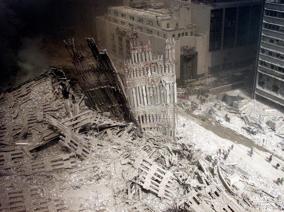 A group of firefighters walk amid rubble near the base of the destroyed south tower of the World Trade Center in New York September 11, 2001.