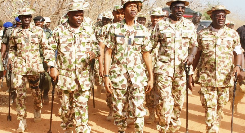 Chief Of Army Staff (COAS), Lt. Gen. Tukur Buratai flanked by troops.