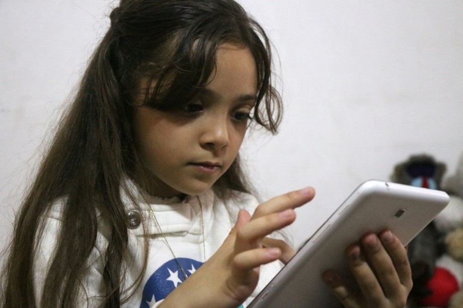 Syrian Bana al-Abed checks her Twitter account in her home in east Aleppo on October 12, 2016.