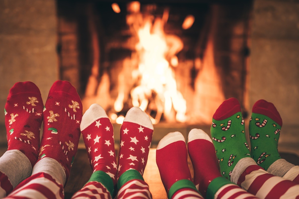 Stopy w skarpetach świątecznych na tle kominka
