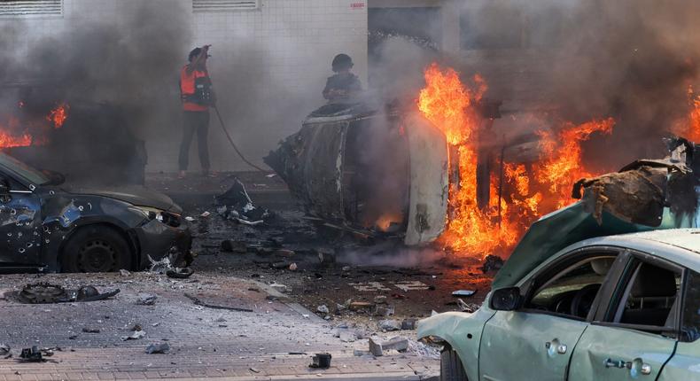 People try to extinguish a fire in Ashkelon, Israel, after Hamas launched a series of surprise attacks on October 7.Ahmad Gharabli/AFP via Getty Images