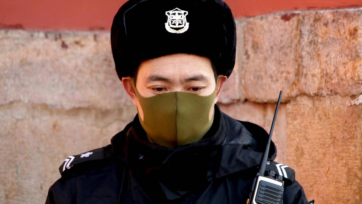 Funkcjonariusz chińskiej policji w masce ochronnej