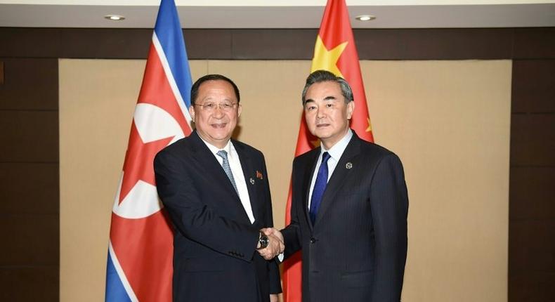 China's Foreign Minister Wang Yi (R) shakes hands with North Korea's Foreign Minister Ri Yong-Ho (L) during their bilateral meeting