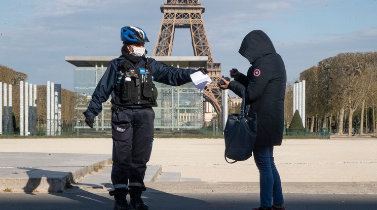 Védőmaszkos rendőrnő egy járókelő papírjait ellenőrzi a párizsi Eiffel-torony előtt a koronavírus-járvány idején / Fotó: MTI/AP/Michel Euler