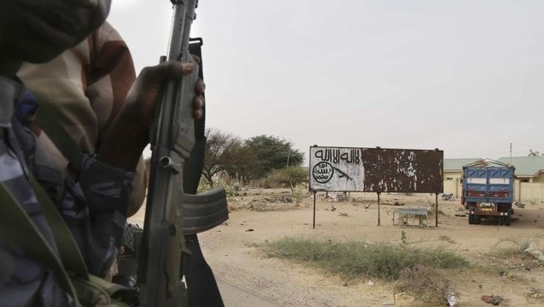 Chadian soldiers drive past a signpost painted by Boko Haram in the recently retaken town of Damasak, Nigeria, March 18, 2015. REUTERS/Emmanuel Braun