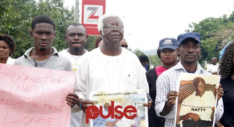 Vetran Nollywood actor, Bruno Iwoha carrying Prince Jame Uches' photograph during the rally in Abuja (Pulse)