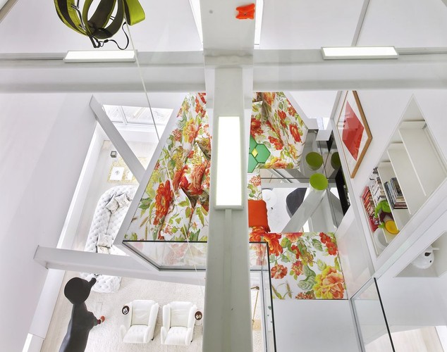 Naprzeciw kominka znajduje się duża huśtawka. Z myślą o dwóch kotach należących do pary zamieszkującej apartament, w ścianach poukrywano kilka sekretnych przejść, które prowadzą wprost do okna nad sypialnią ich właścicieli. Na zdjęciu: SkyHouse, balkon z kącikiem do wypoczynku nad salonem, źródło: David Hotson_Architect