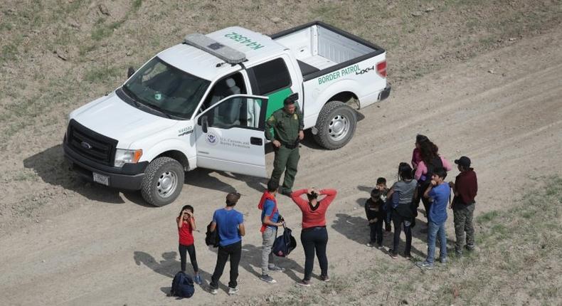 Asylum seekers turn themselves in to a US Border Patrol agent after crossing from Mexico into the United States on November 7, 2018 in Mission, Texas