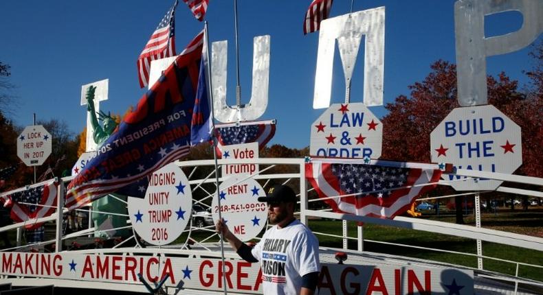 A man poses in front of a Trump sign as he waits to see US Republican Presidential nominee Donald Trump address supporters on November 6, 2016 in Sterling Heights, Michigan