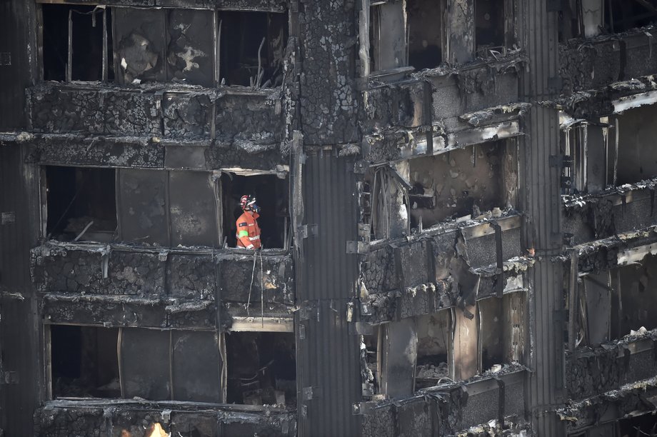 An investigator searches a burnt-out Grenfell apartment.