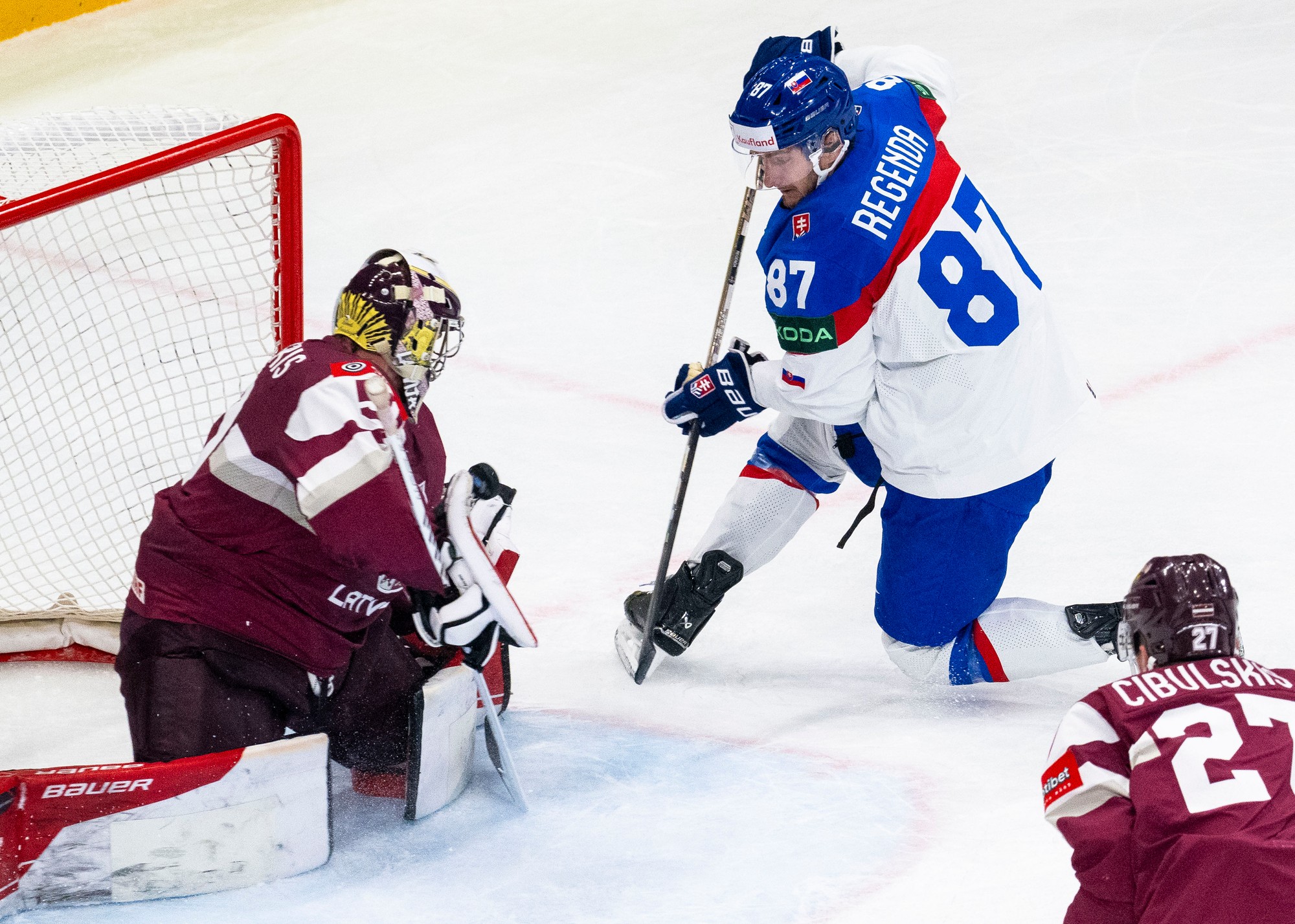 Zľava lotyšský brankár Kristers Gudlevskis, Pavol Regenda (Slovensko) a Oskars Cibulskis (Lotyšsko).