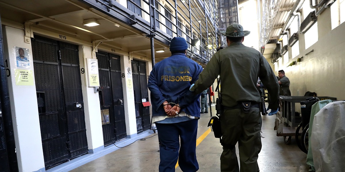 An inmate is escorted through San Quentin State Prison in California.