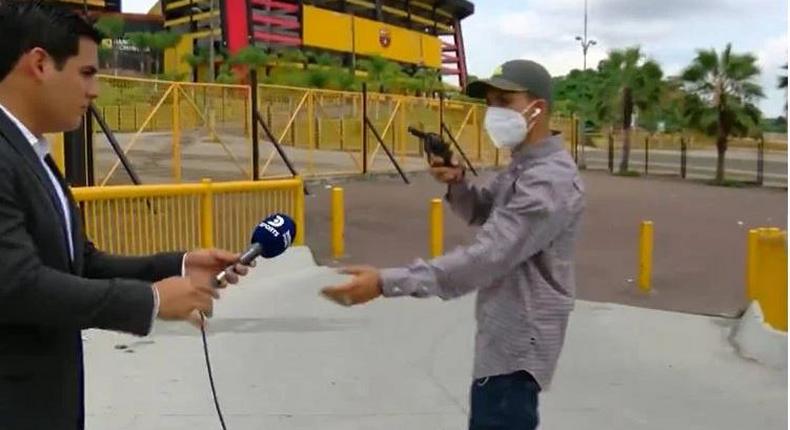 Mask-wearing robber robs journalist at gunpoint during live report