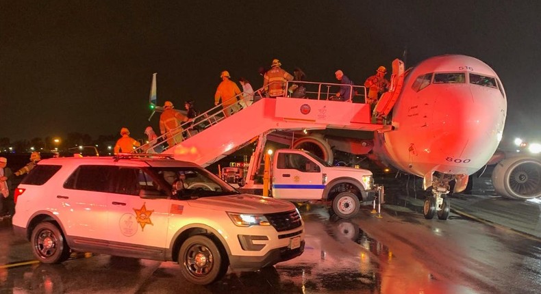 Passengers deplane Alaska Airlines Flight 1288 on Sunday after the aircraft made a rocky landing at California's John Wayne Airport.Orange County Fire Authority