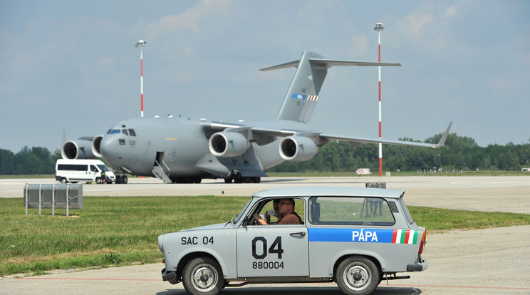 Egy Boeing C-17-es teherszállító repülőgép és a kiszolgáló személyzet Trabant személygépkocsija a pápai bázisrepülőtéren 2012. július 27-én / Fotó: MTI/Koszticsák Szilárd