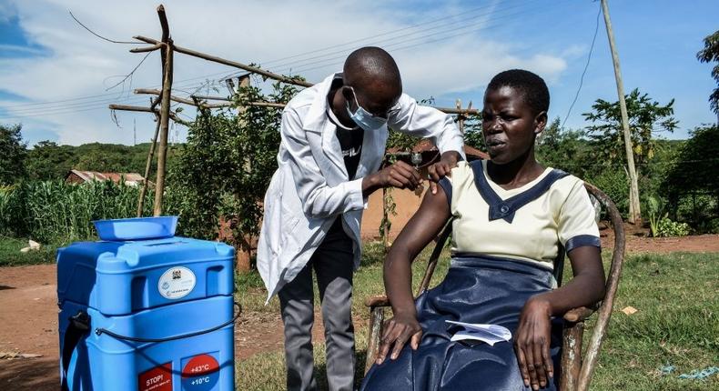 TOPSHOT - A medical health worker injects the Oxford/AstraZeneca Covid-19 vaccine to a woman as they visit door-to-door to deliver the vaccines to people who live far from health facilities in Siaya, Kenya, on May 18, 2021. (Photo by BRIAN ONGORO/AFP via Getty Images)