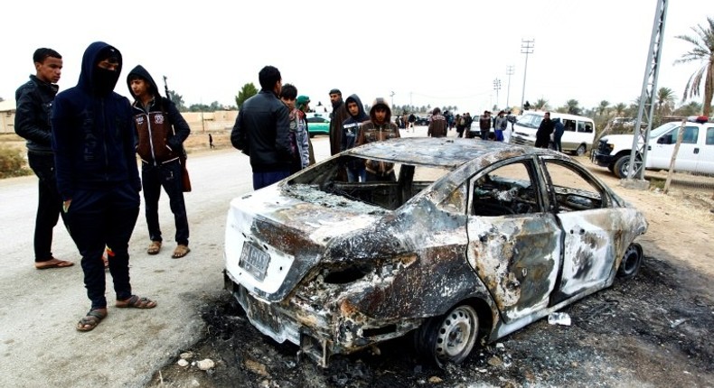 Security forces and locals gather at the site of an attack on a police checkpoint, near the town of Qadisiyah, 40km south of the holy Shiite Iraqi city of Najaf on January 1, 2017