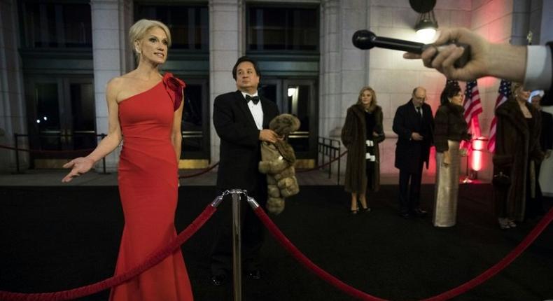 George Conway stands in the background as his wife Kellyanne Conway speaks to reporters at an event for President Donald Trump's 2017 inauguration