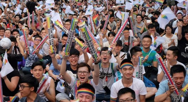 Same-sex activists cheered, hugged and wept outside the parliament in Taipei as they celebrated the landmark decision
