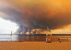 Posetioci plaže odmaraju se na plaži Mučik na obali jezera Lakano u Lakanou, na jugozapadu Francuske, dok požar besni u Žirondi, 24. jul 2026.