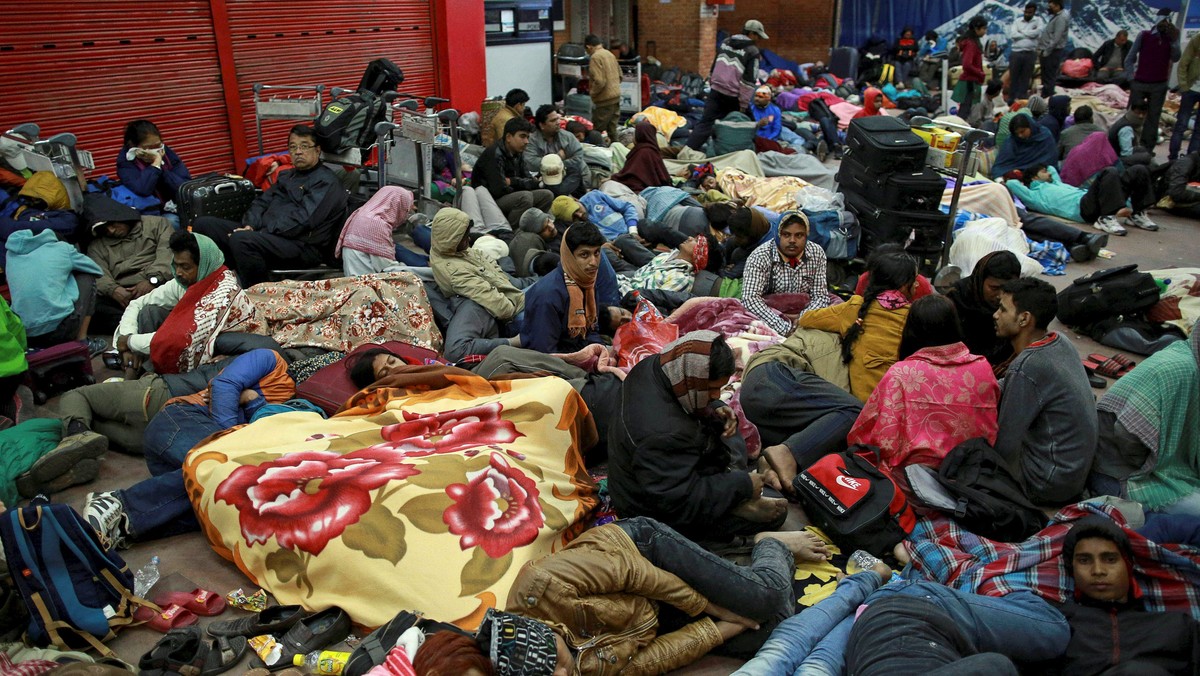 People wait outside the departure terminal at the airport in Kathmandu