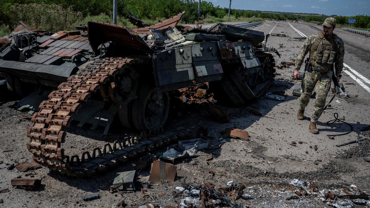 Ukraiński żołnierz obok wraku czołgu zniszczonego w czasie walk o Robotyne