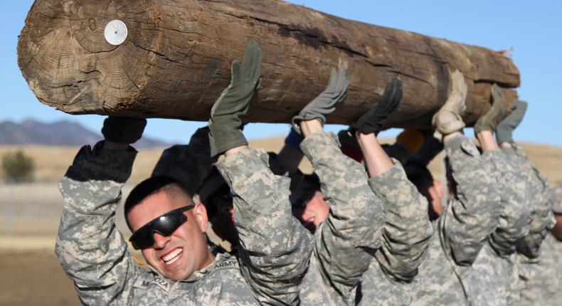 US soldiers lift a heavy log over their heads 20 times while competing in the Ivy Heptathlon during Iron Horse Week, January 28, 2015.