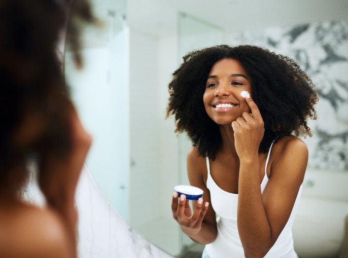 Applying a night cream is one of the ways to prevent and clear wrinkles [Travel Noire]