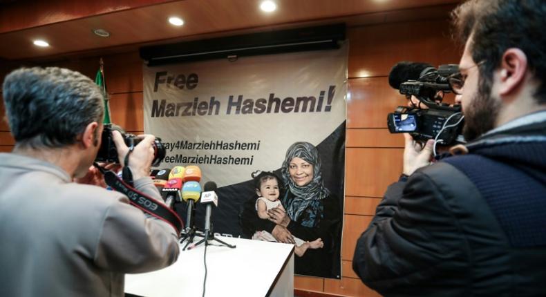 Journalists in Tehran photograph and film a poster calling for the release of Marzieh Hashemi, a US-born presenter for Iran's Press TV who was arrested on a visit to her birth country