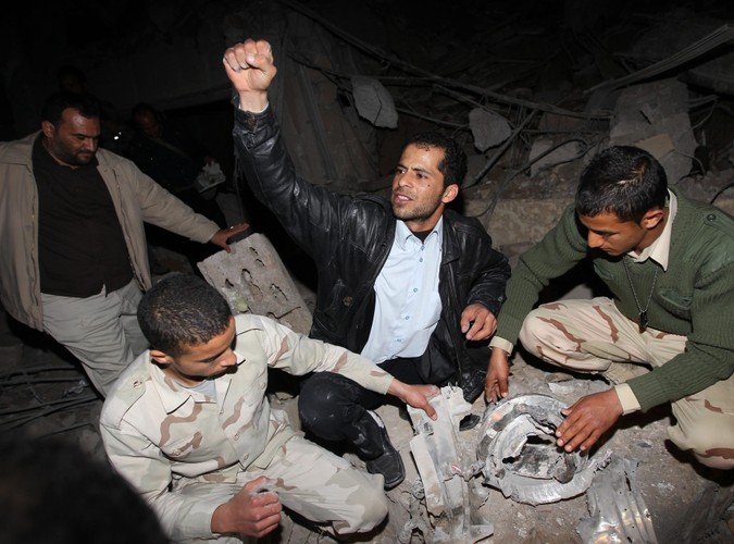 Libijczycy na gruzach budynku w Trypolisie, należącego do administracji Muammara Kadafiego, położonego zaledwie 50 metrów od namiotu, w którym Kadafi przyjmuje gości