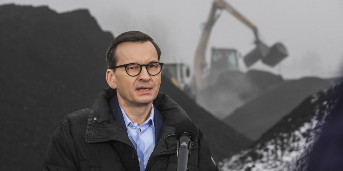 Premier Mateusz Morawiecki zimą na tle składu węgla