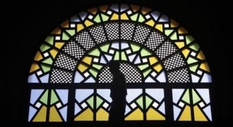 A man walks past stained glass windows inside the Gaddafi National mosque after Friday prayers in Uganda's capital Kampala in this Oct. 21, 2011 file photo. Although Uganda is largely Christian, Hassan Muwanguzi, who converted to Christianity from Islam, is being persecuted by Muslim extremists