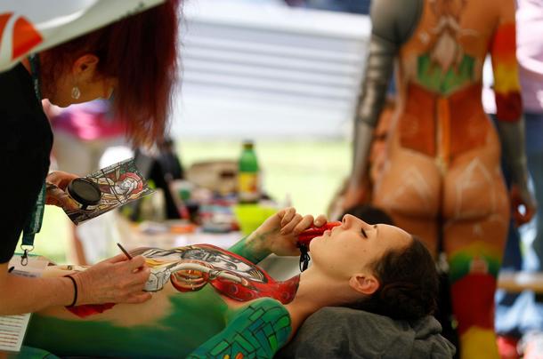 An artist touches up makeup on a model during the World Bodypainting Festival 2017 in Klagenfurt