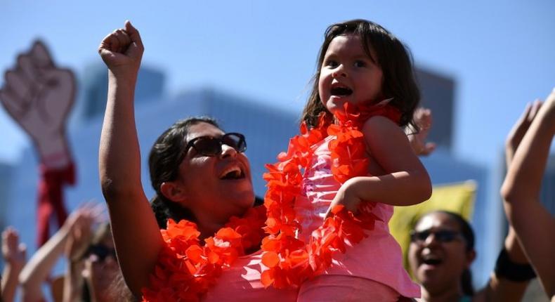 A mother and daughter cheer at the A Day Without a Woman rally honoring International Women's Day, in Los Angeles, California