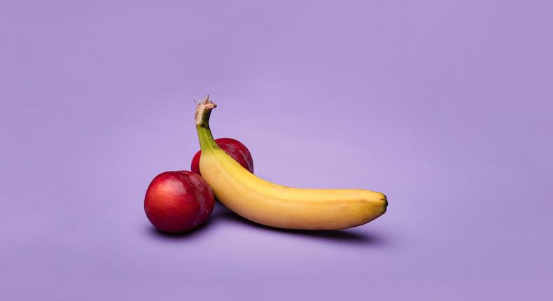 Yellow banana fruit and peaches on purple background [Image: Deon Black]