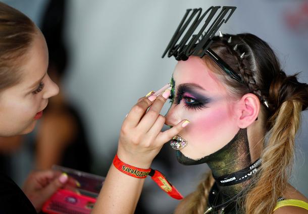 An artist touches up makeup on a model during the World Bodypainting Festival 2017 in Klagenfurt