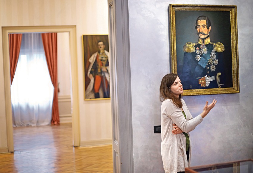 Ružica Opačić, autorka postavke, ispred portreta kneza Aleksandra Karađorđevića