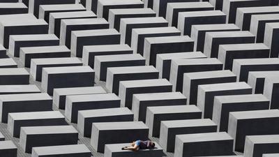 FILE PHOTO: A girl rests on a concrete column of the Holocaust memorial in Berlin
