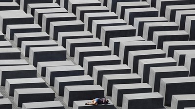 FILE PHOTO: A girl rests on a concrete column of the Holocaust memorial in Berlin