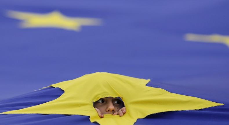 A child peers through a cut made in one of the stars that make up the European Union flag, during a support rally organised to mark the EU's 60th anniversary of the Treaty of Rome in downtown Bucharest, Romania, March 25, 2017.